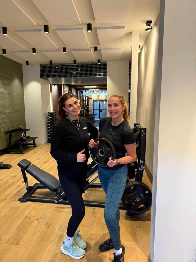 Britte en trainer Lou na een succesvolle training bij DreamFit, zichtbaar trots in de studio.